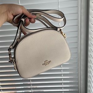 White-cream color coach bag with detachable shoulder strap.